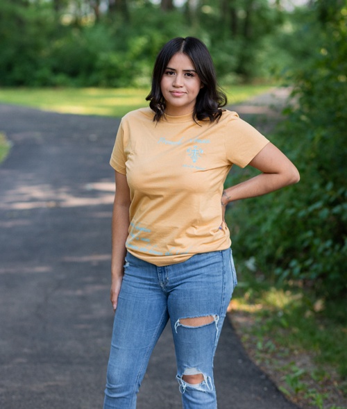 a female model wearing the orange blessed and redeemed shirt with blue text