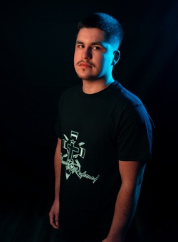 a male model wearing a black blessed and redeemed shirt with a white logo, facing left and looking directly at the camera